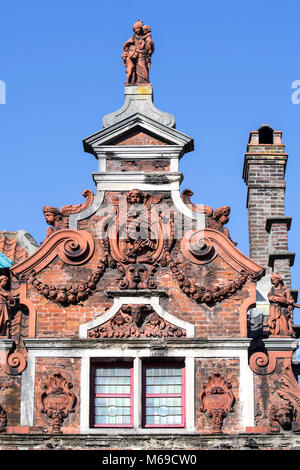 Flute Player / de Hel, terracotta sculptures, festoons and volutes decorating gable of 17th century baroque house façade in the city Ghent, Belgium Stock Photo