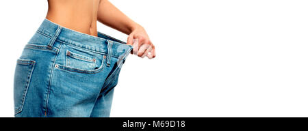 Woman is measuring waist after weight loss, diet concept. Woman in oversize jeans Stock Photo