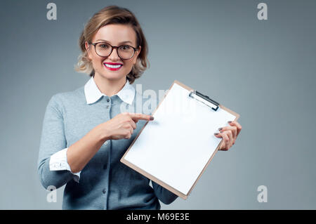 Business woman showing blank paper clipboard Stock Photo