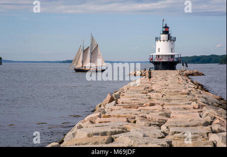 Old Schooner sails past Spring Point lighthouse on a warm summer day in Portland Maine. Windjammers, as they are called, are a favorite tourist attrac