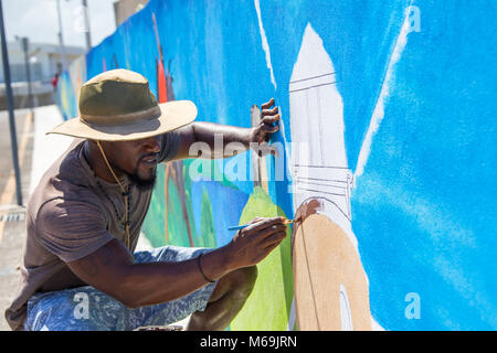 Antiguan man painting a windmill, St John's, Antigua Stock Photo