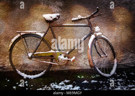 Old forgotten bicycle under the snow on a wall, snow scene. Troinex, Genève Suisse. Geneva. Switzerland. Europe Stock Photo
