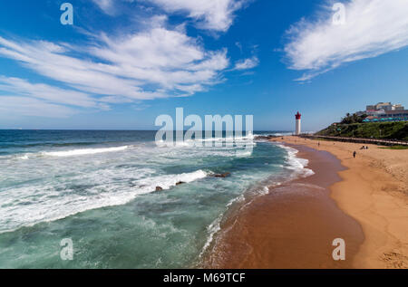 Waves breaking on beach, lighthouse city skyline and blue cloudy sky in Umhlanga,  Durban, South Africa Stock Photo