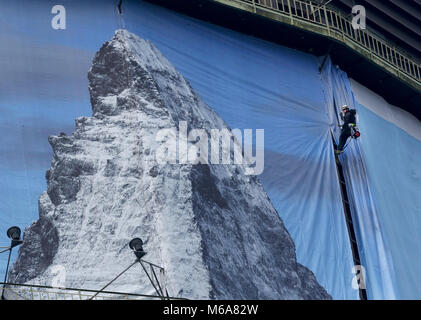 02 March 2018, Germany, Oberhausen: Industrial climbers put up a 1400 square metre big poster for the exhibition 'Der Berg ruft' (lit. the mountain calls) at the Oberhausen gasometer. The exhibition takes place from 16 March to 31 December 2018 and displays a monumental sculpture of the Matterhorn at the 100 metre high airspace of the gasometer. Photo: Roland Weihrauch/dpa Stock Photo