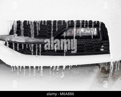 A lot of icicles formed on the grille of a white car during the freezing temperatures of winter due to the so called Beast from the East Stock Photo