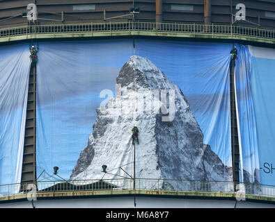 02 March 2018, Germany, Oberhausen: Industrial climbers put up a 1400 square metre big poster for the exhibition 'Der Berg ruft' (lit. the mountain calls) at the Oberhausen gasometer. The exhibition takes place from 16 March to 31 December 2018 and displays a monumental sculpture of the Matterhorn at the 100 metre high airspace of the gasometer. Photo: Roland Weihrauch/dpa Stock Photo