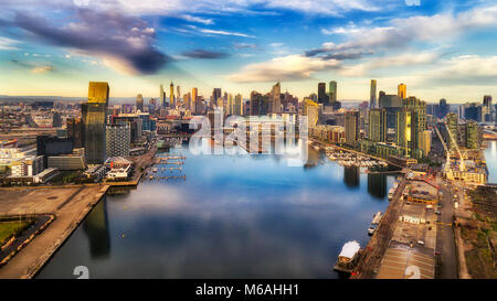 Yarra river surrounded by Melbourne suburb Docklands in elevated aerial view facing city CBD waterfront and towers with marina and yachts. Stock Photo