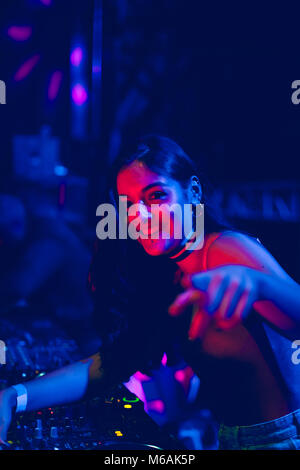Young woman Dj playing music at Summer Night Festival. Fun, youth, entertainment and fest concept. Stock Photo