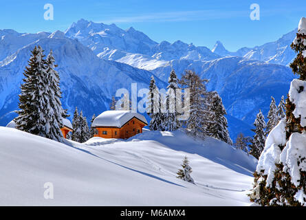 Winter landscape with deep snow-covered chalets, in the back summit of Dom, 4545m, and Matterhorn, 4478m, Riederalp Stock Photo