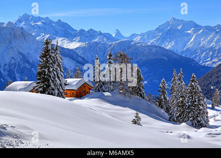 Winter landscape with deep snow-covered chalets, in the back summit of Dom, 4545m, and Matterhorn, 4478m, Riederalp Stock Photo