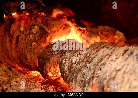 View into a fireplace with close up of a blazing burning logs. Stock Photo