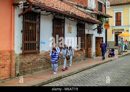 Bogota, Colombia - January 27, 2017: Local Colombian people walk through the narrow streets of the historic La Candelaria District in the capital city Stock Photo