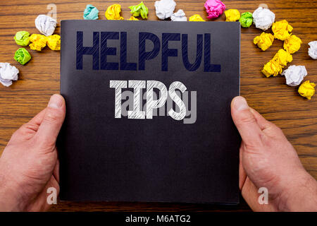 Word, writing Helpful Tips. Business concept for Help in FAQ or Advice, written notepad notebook book on the wooden wood background with man businessm Stock Photo