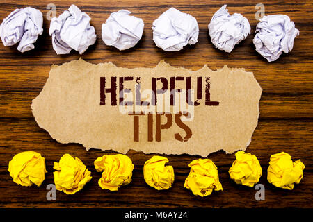 Conceptual hand text word Helpful Tips. Business concept for Help in FAQ or Advice, Written on sticky, wooden with sticky, many folded paper white and Stock Photo
