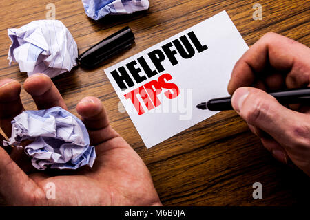 Handwriting text   Helpful Tips. Concept for Help in FAQ or Advice, written on notebook note paper on wooden background with folded paper meaning thin Stock Photo