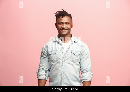 The happy business man standing and smiling against pink background. Stock Photo