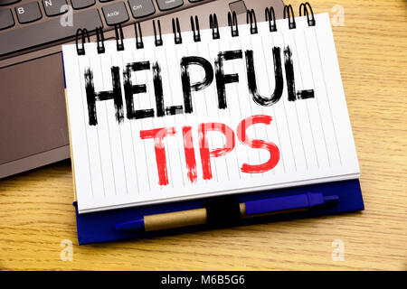 Word, writing Helpful Tips. Business concept for Help in FAQ or Advice, written on notebook book on wooden background in the Office with laptop Stock Photo