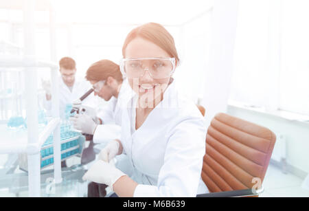 Investigator checking test tubes, Woman wears protective goggles Stock Photo