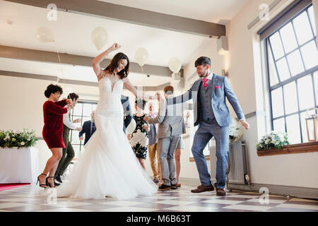 Newly wed couple are enjoying dancing with all of their guests on their wedding day. Stock Photo