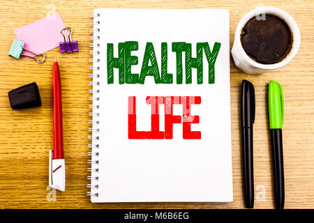Hand writing text caption showing Healthy Life. Business concept for Good Health Food Written on notepad paper background with space office view with  Stock Photo