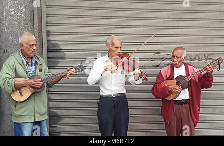 Three Senior Citizens Street Musicians playing the Violin and Cuatro  in Caracas, Venezuela. Active Seniors. Elderly men. Stock Photo