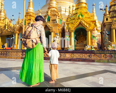 Tourists mother and child visiting Shwedagon or Great Dagon Pagoda in Yangon. Myanmar. Stock Photo