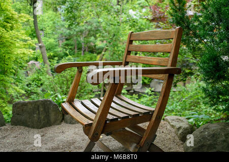 weathered wood chair sitting outside in Japanese Zen garden Stock Photo