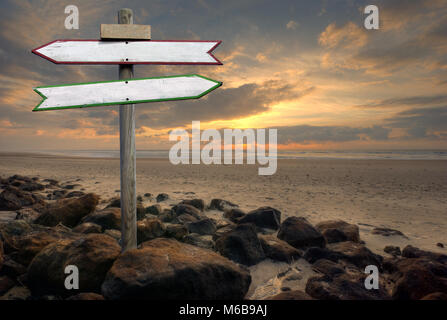 Double directional signs on a beach Stock Photo