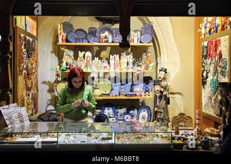 KRAKOW, POLAND - MAY 12, 2014: Vendor sells Polish traditional handicraft souvenirs in Cloth Hall, Krakow. Sukiennice Cloth Hall is part of UNESCO Wor Stock Photo