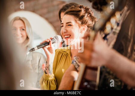 Entertianment at a wedding. A female singer is interacting with the crowd while a man plays an acoustic guitar. Stock Photo