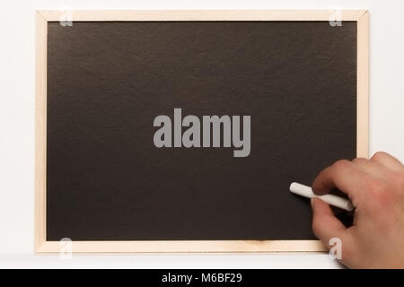 A male hand writing on blackboard against white background using white chalk Stock Photo