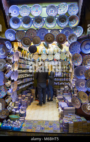 Tourists shopping in a Moroccan ceramics and pottery shop in the Old Medina souks in Fes, Morocco