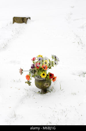Silk flowers on graves in winter. Stock Photo