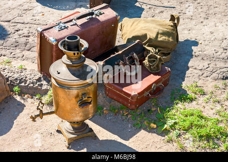 Vintage travel luggage with old suitcases and copper samovar in sunny day Stock Photo