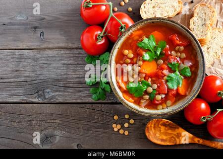 Homemade tomato, lentil soup, above view corner border with copy space on a rustic wood background Stock Photo