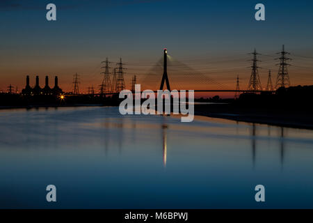Suspension bridge over the river Dee and power station at Connah's Quay, Deeside, North Wales with reflections in the still water Stock Photo