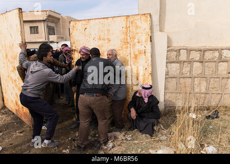 Mosul, Iraq. 8th December 2016 - Mosul locals try to covince their way into a barricaded school to seek shelter as fighting continues in the city of M Stock Photo