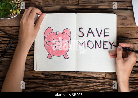 Elevated View Of A Businessperson Drawing Save Money Concept On Notebook Stock Photo