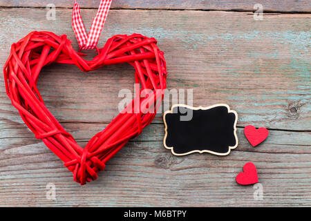 Valentine's day background with red hearts  and a blackboard on wooden planks. Space for text. Valentine's day concept.Top view. Stock Photo