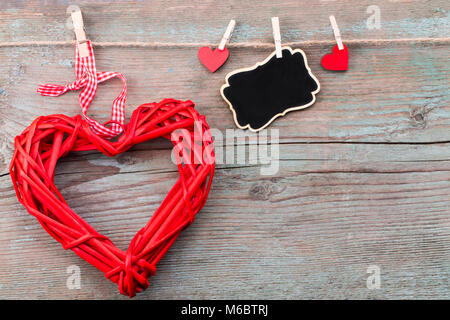 Valentine's day background with red hearts  and a blackboard on wooden planks. Space for text. Valentine's day concept.Top view. Stock Photo