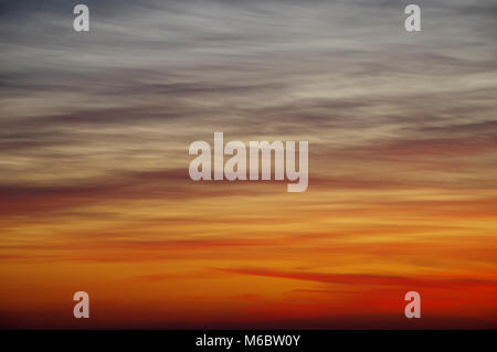Orange evening sky with a dramatic belt of clouds. Perfect color after sunsets. Stock Photo