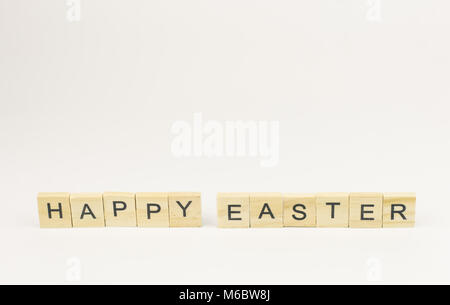 Text wooden blocks spelling the word happy easter on white background Stock Photo