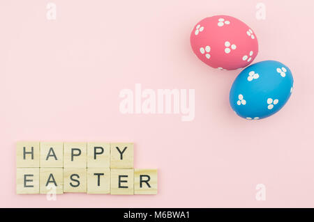 Text wooden blocks spelling the word happy easter on pink background Stock Photo