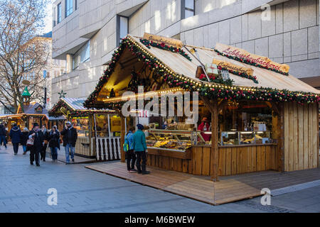 Shoppers and Christmas market food stalls in city centre pedestrianised street. Munich, Bavaria, Germany, Europe Stock Photo