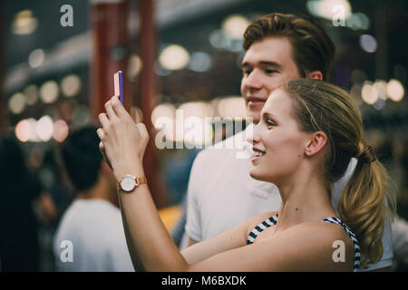 Young couple are taking tourist photos in Queen Victoria market, Australia. Stock Photo