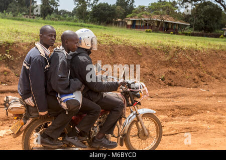 3 men on a motorcycle Hoima Village en route from Murchisons falls National Park to Kimbale National Park south-west Uganda Africa Stock Photo