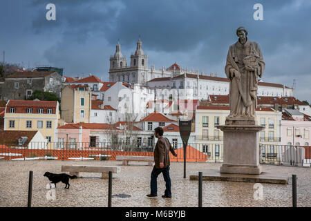 LISBON, PORTUGAL - January 28, 2011: Unknown man with the dog in viewpoint of Largo das Portas do Sol, the Alfama neighbourhood, the old quarter of Li Stock Photo