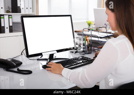 Young Businesswoman Working On Computer With Blank White Screen Stock Photo