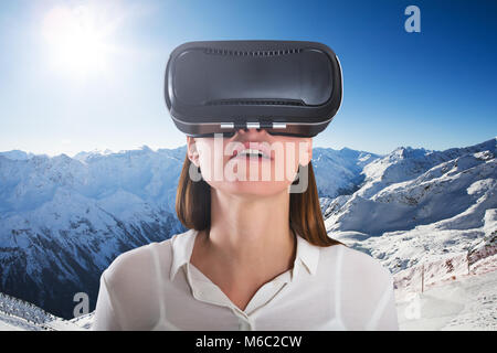 Close-up Of A Female Wearing Virtual Reality Glasses In Front Of Snowy Mountain Stock Photo