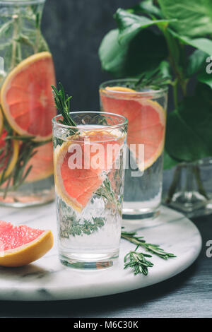 Cold cocktails with grapefruit and rosemary on a white marble serving tray. Stock Photo